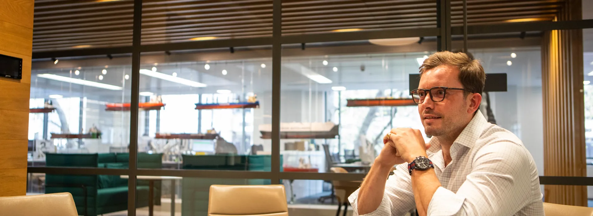 Man sitting at a table in a modern office.