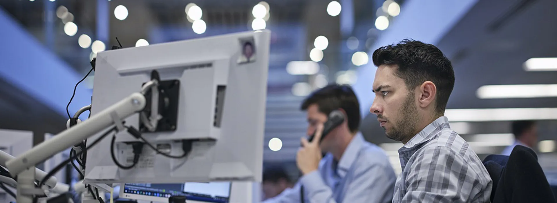Man working at a desk with dual monitors.