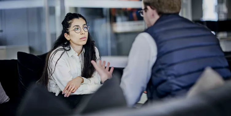 Man talking to a woman on the couch, opposite eachother