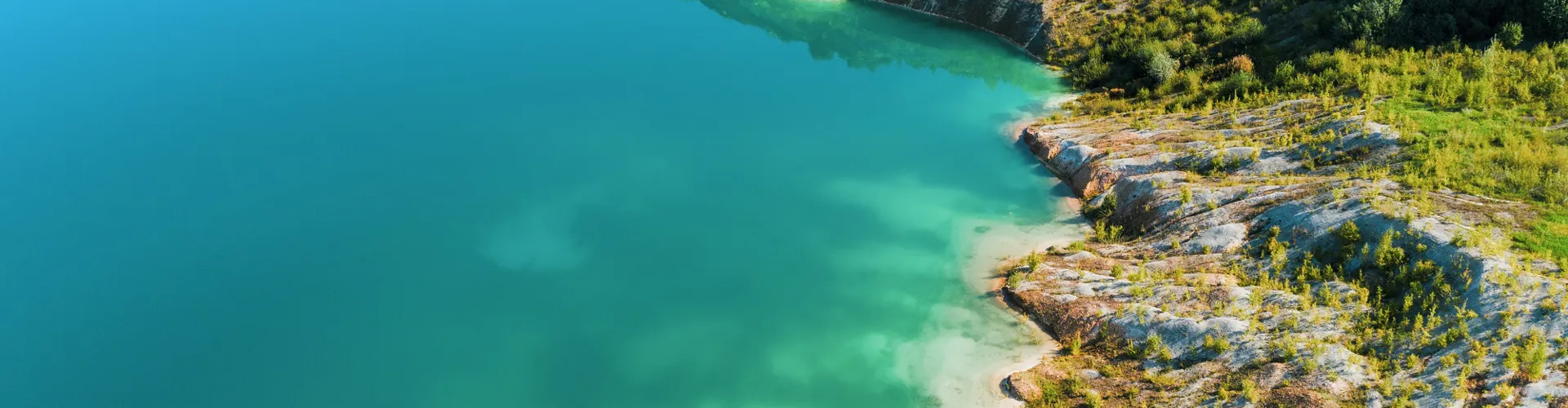 Inactive gypsum quarry. In the quarry is a lake with blue water.