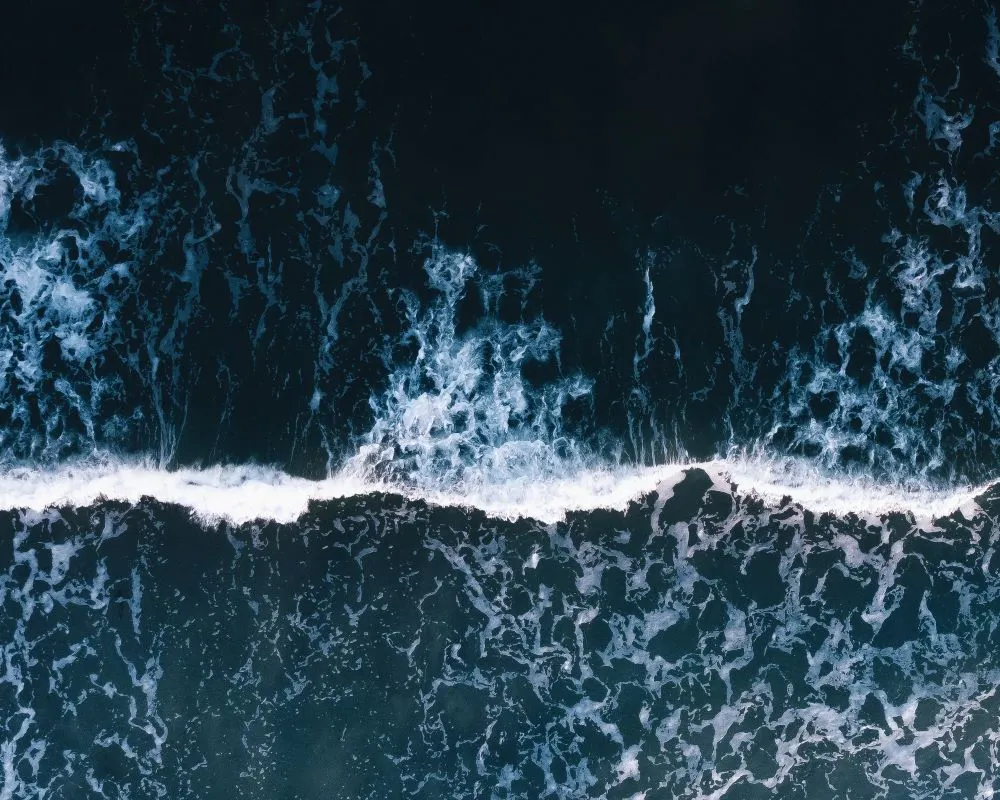 Aerial view of ocean waves and foam.