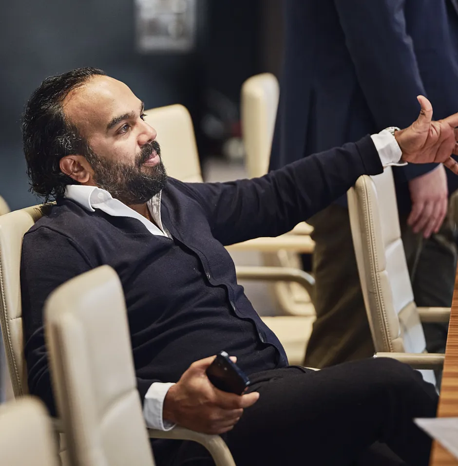 man sitting in a meeting room and pointing