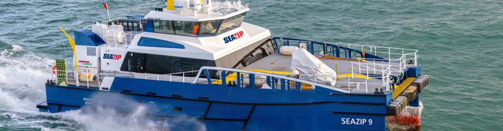 A blue and white vessel named "SEAZIP 9" at sea.