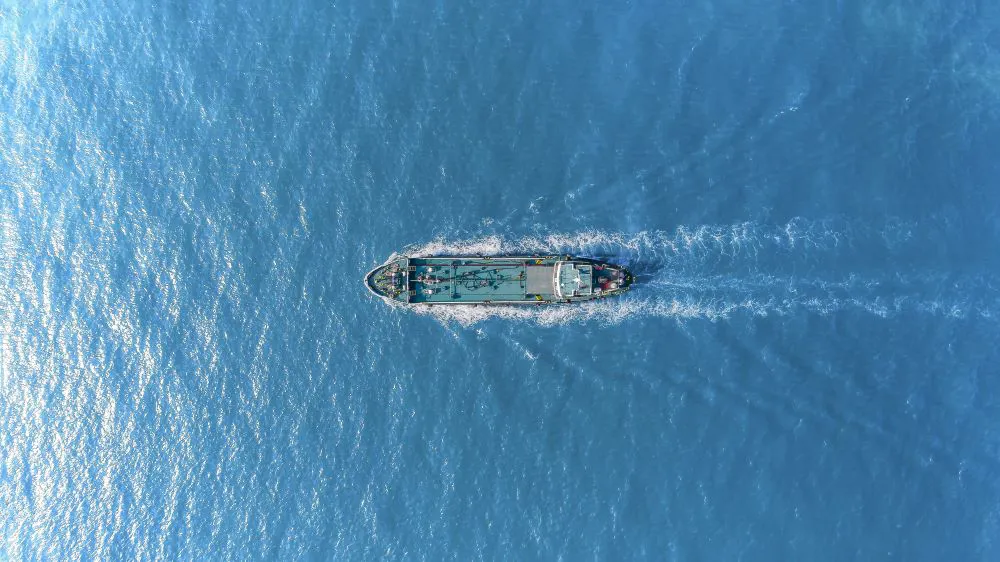 Aerial view of a ship on blue water.