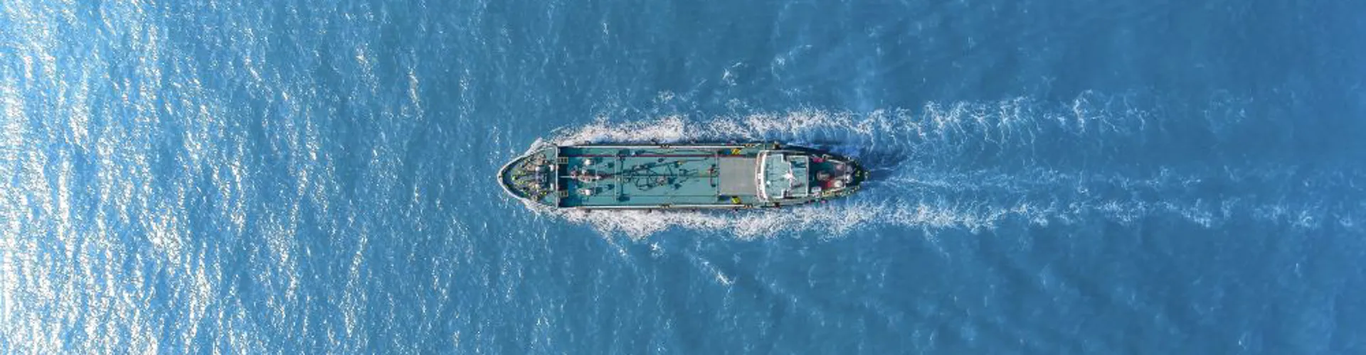 Aerial view of a ship on blue water.