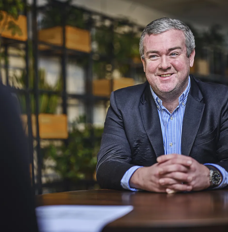 man talking and smiling at table, talking to someone