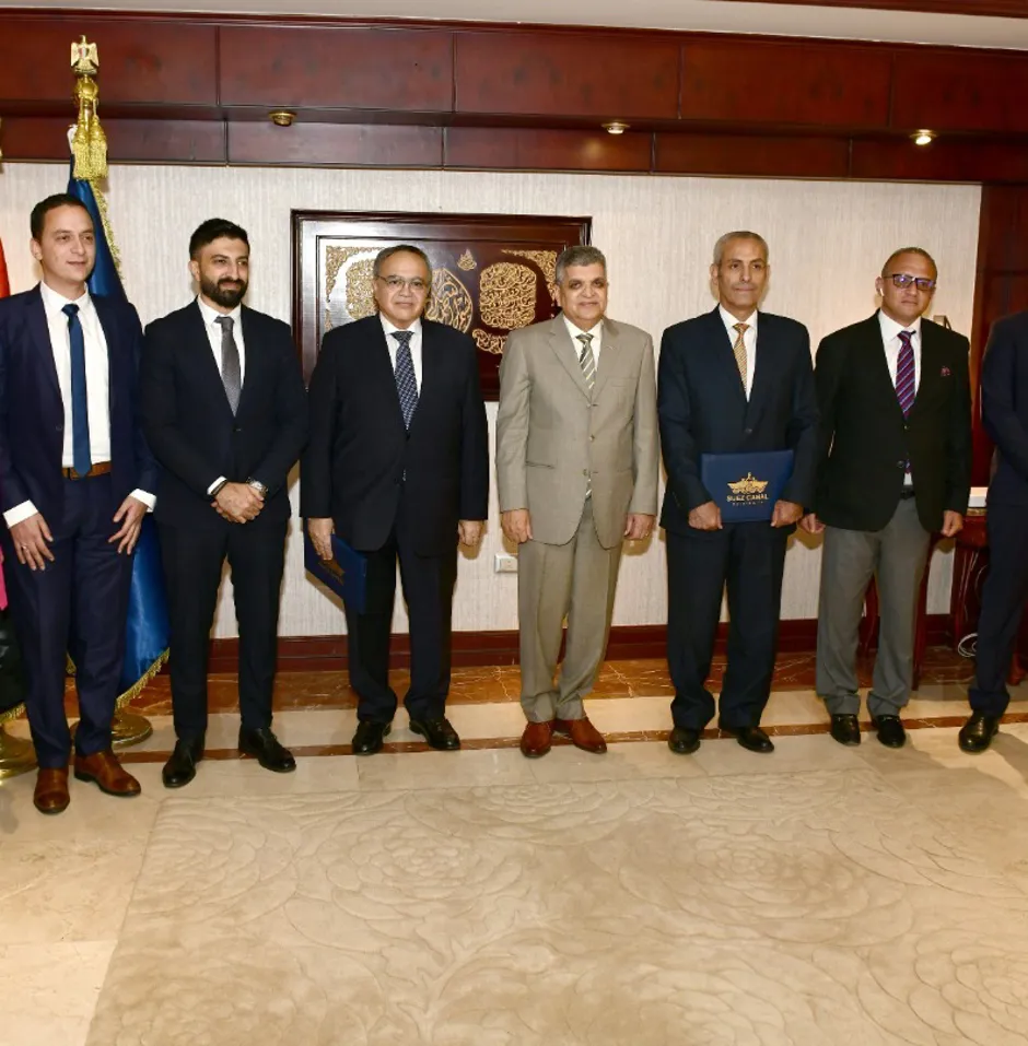 Group of professionals posing indoors with flags.