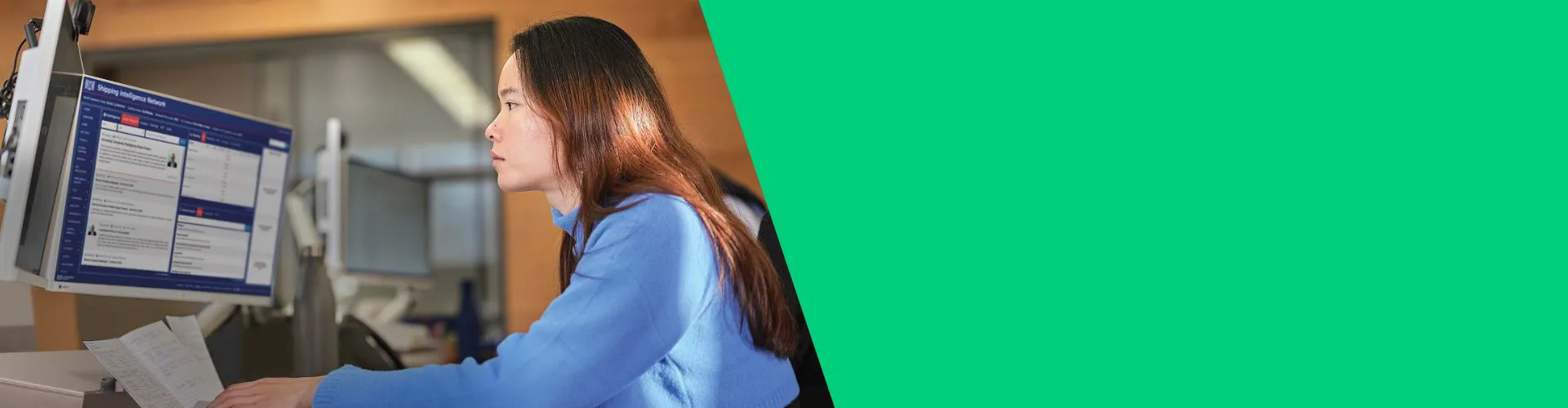Person working at a computer with a blue sweater.