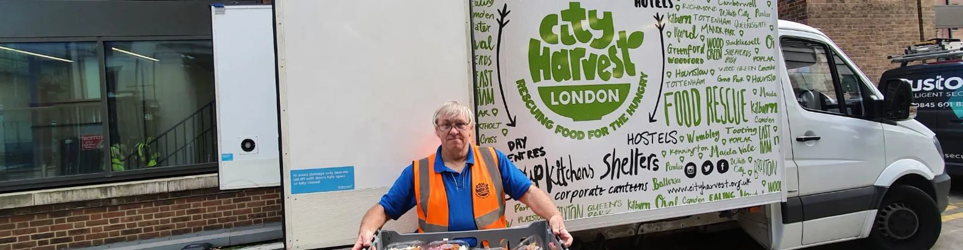man carrying tray of food into van