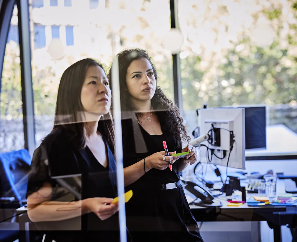 close up of two women looking at notes in a brainstorming meeting