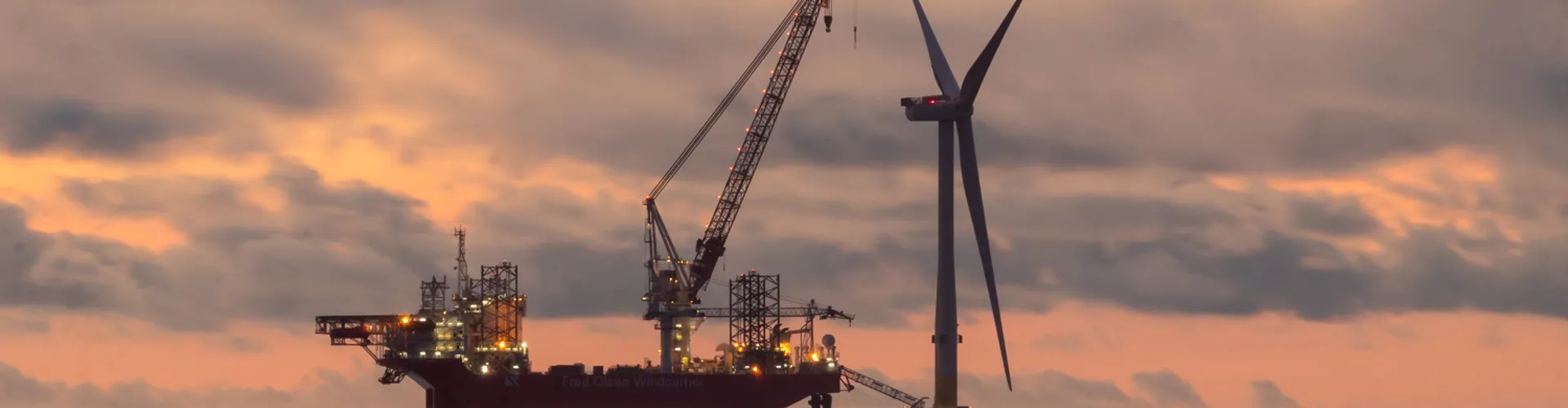 Offshore wind turbine at sunset