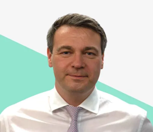 A man in a white shirt and tie against a colorful background.