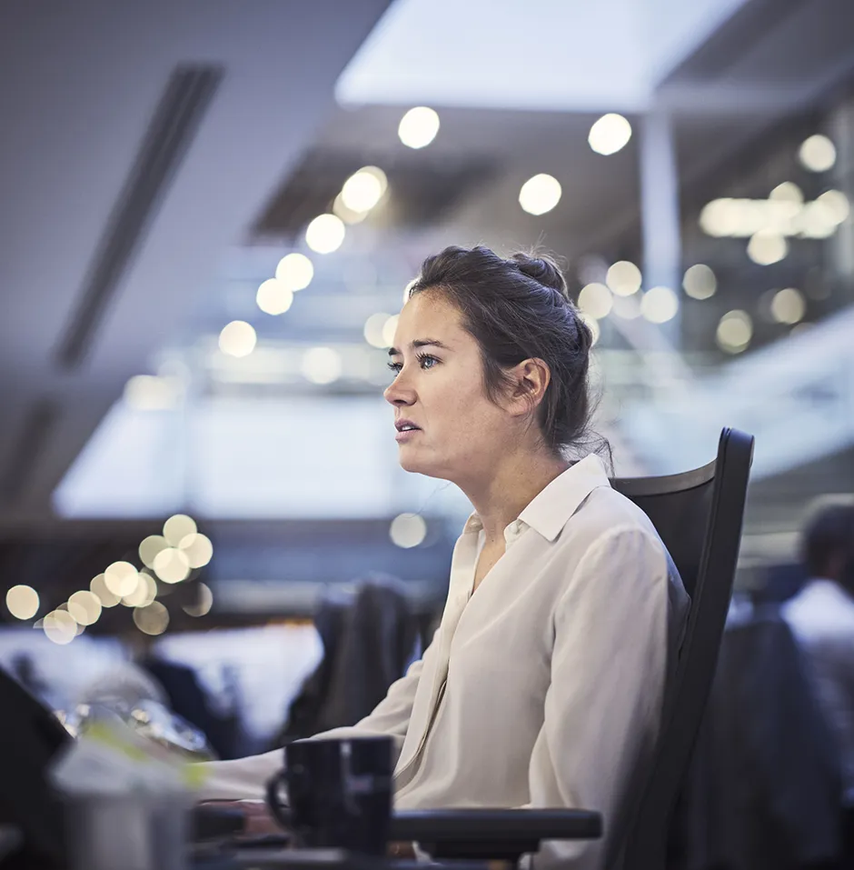 woman at her desk looking up at her computer screen