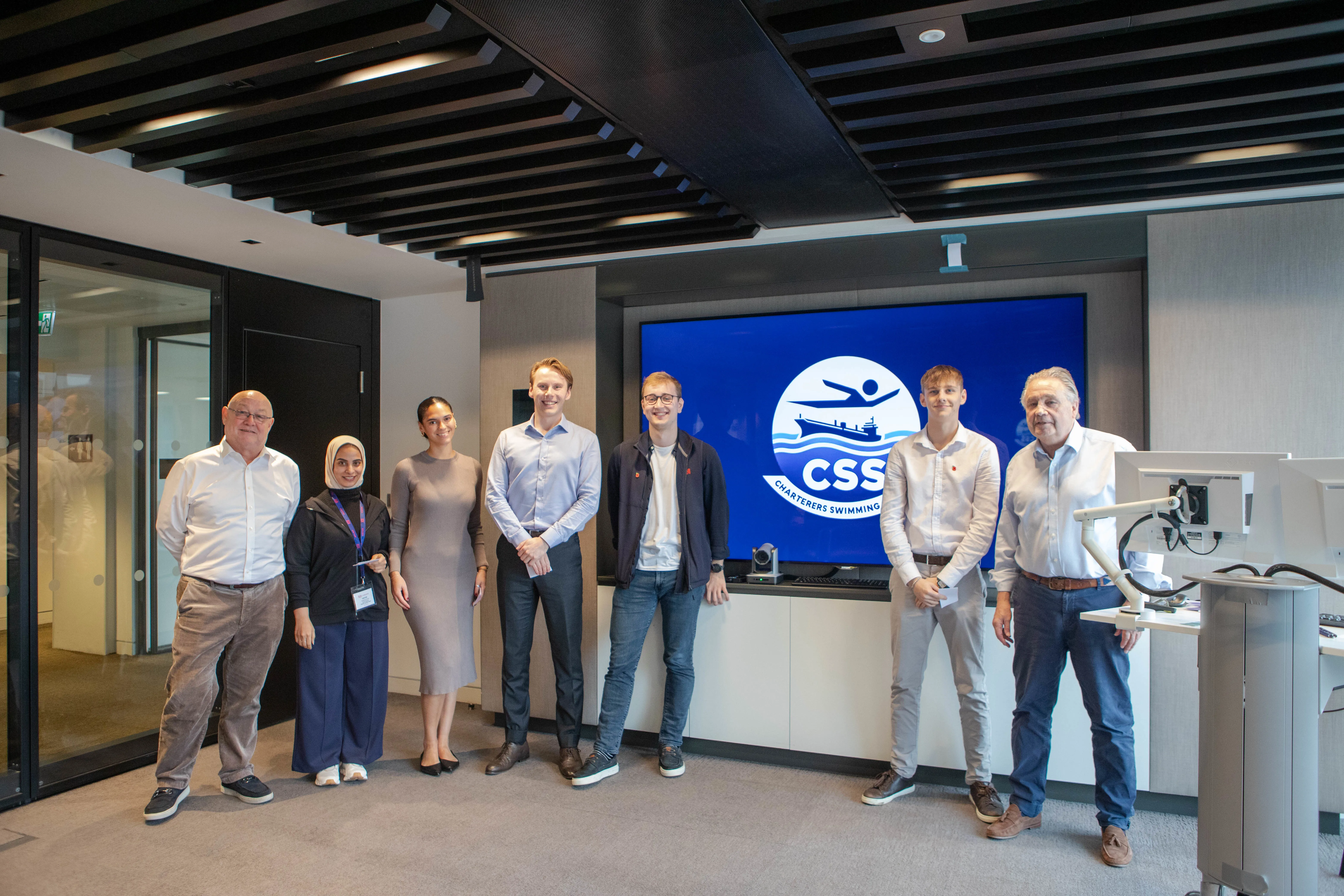 A group of seven people in an office setting.