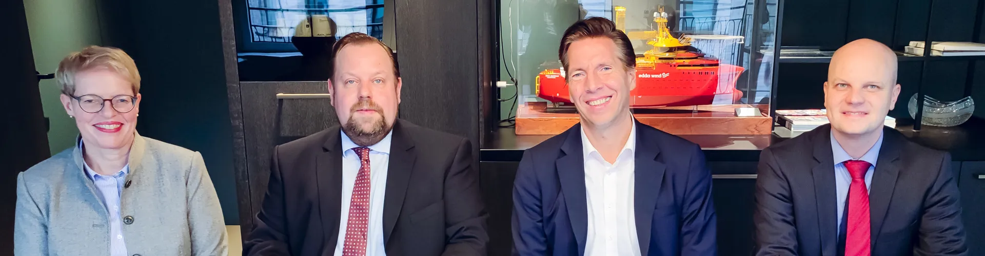 Four professionals seated at a table with documents.