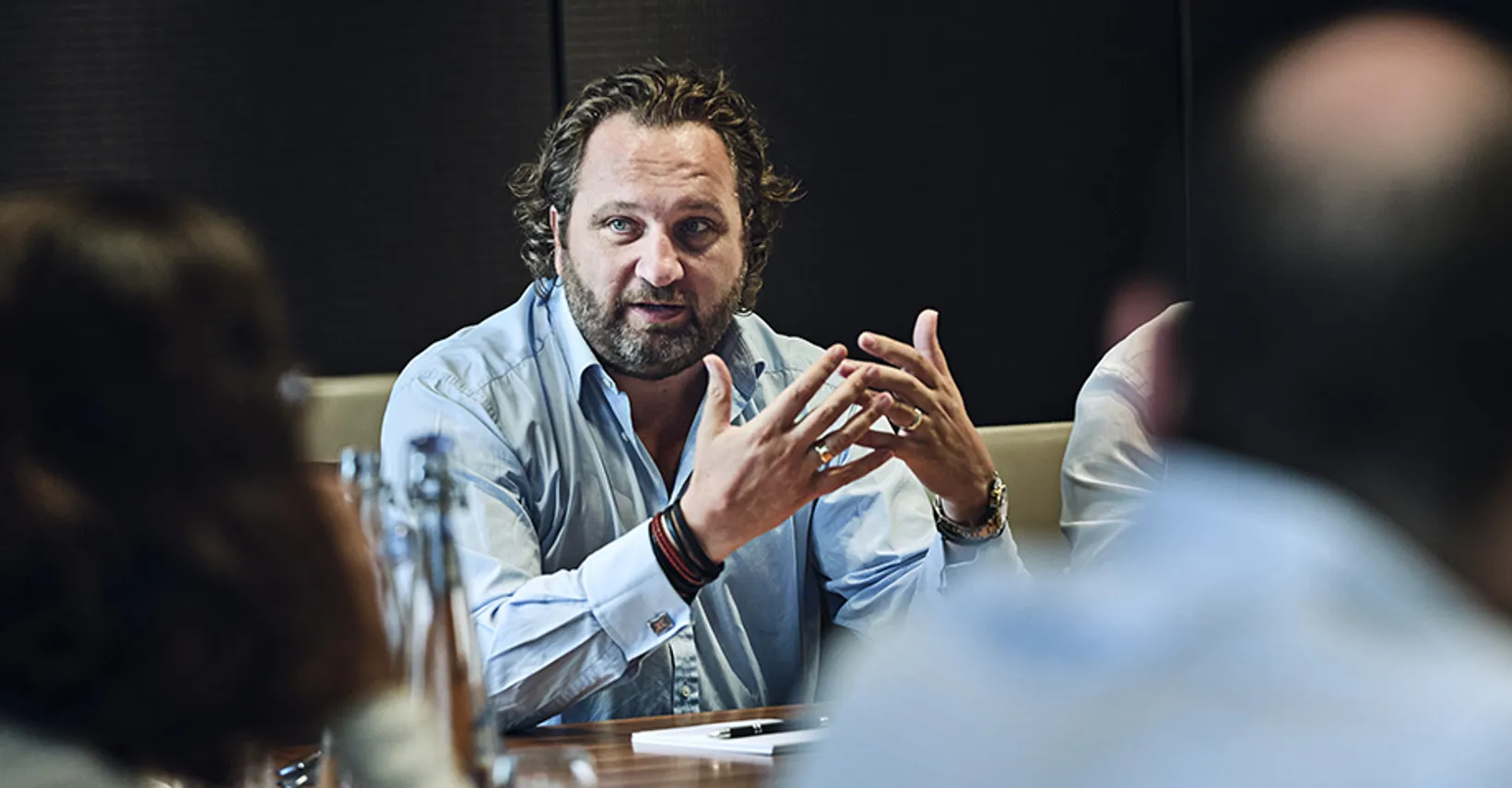 CEO talking sat at meeting table with analysts