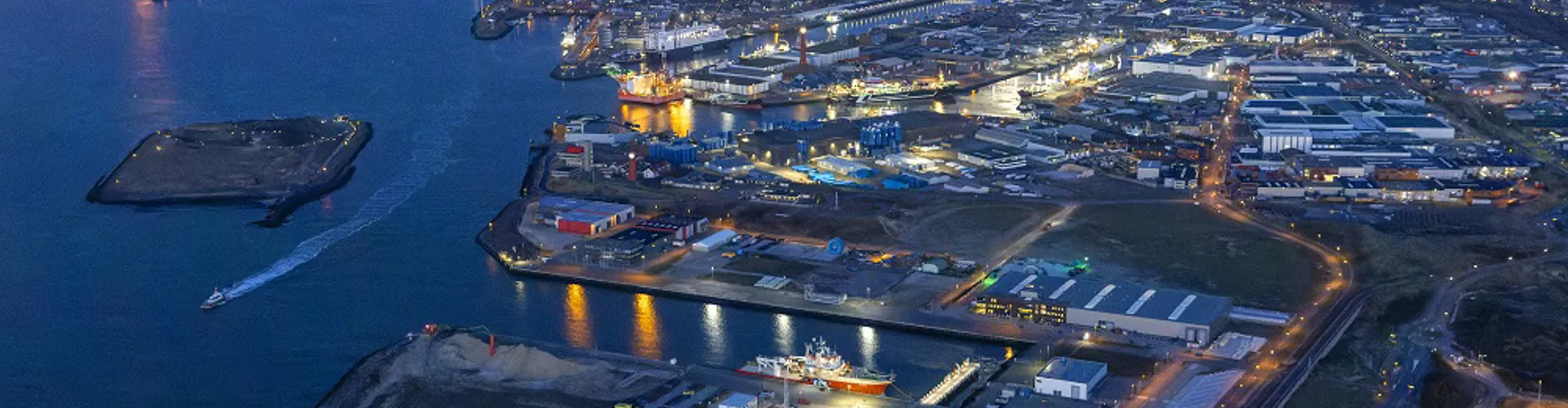 Aerial view of a harbor with ships and warehouses.