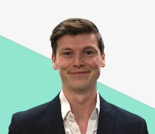 Smiling man in a suit against a light background.