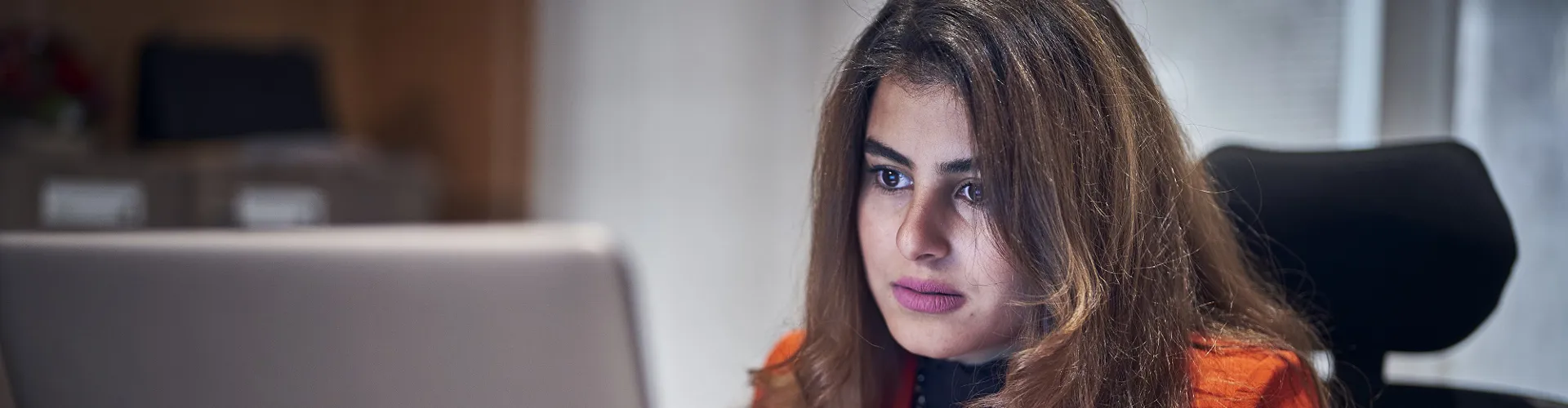 close up of a woman on a laptop in an office