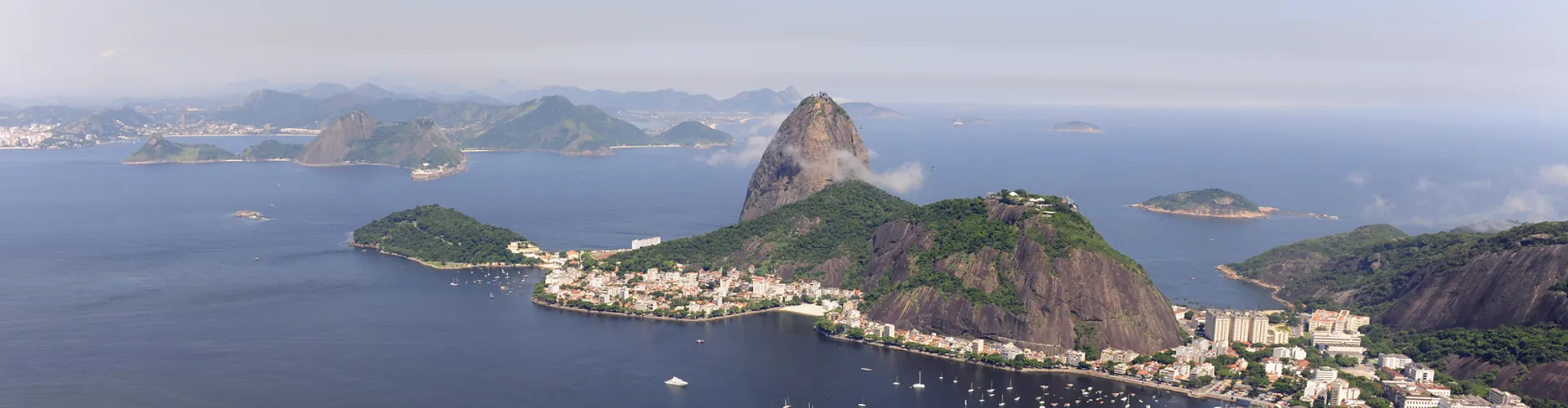 Panoramic view of a modern city skyline at sunset, featuring the lotus-shaped ArtScience Museum structure.