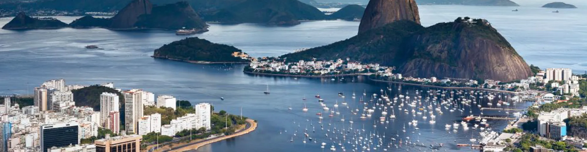 Scenic view of a coastline with hills and boats.