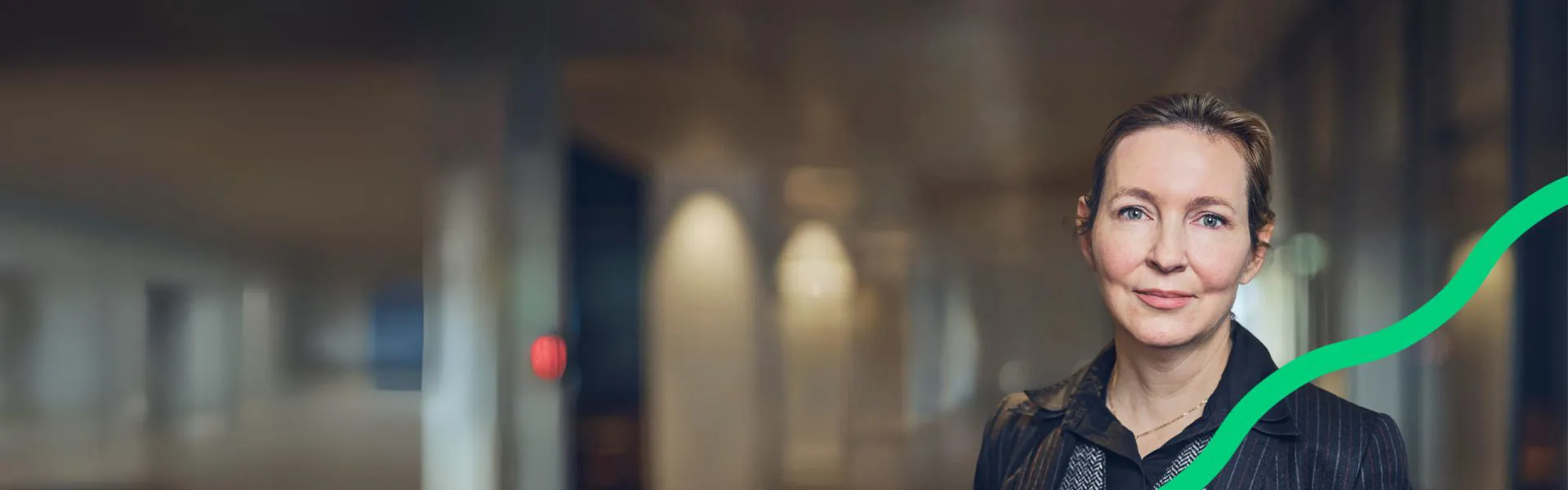 Woman in a professional setting with soft lighting.
