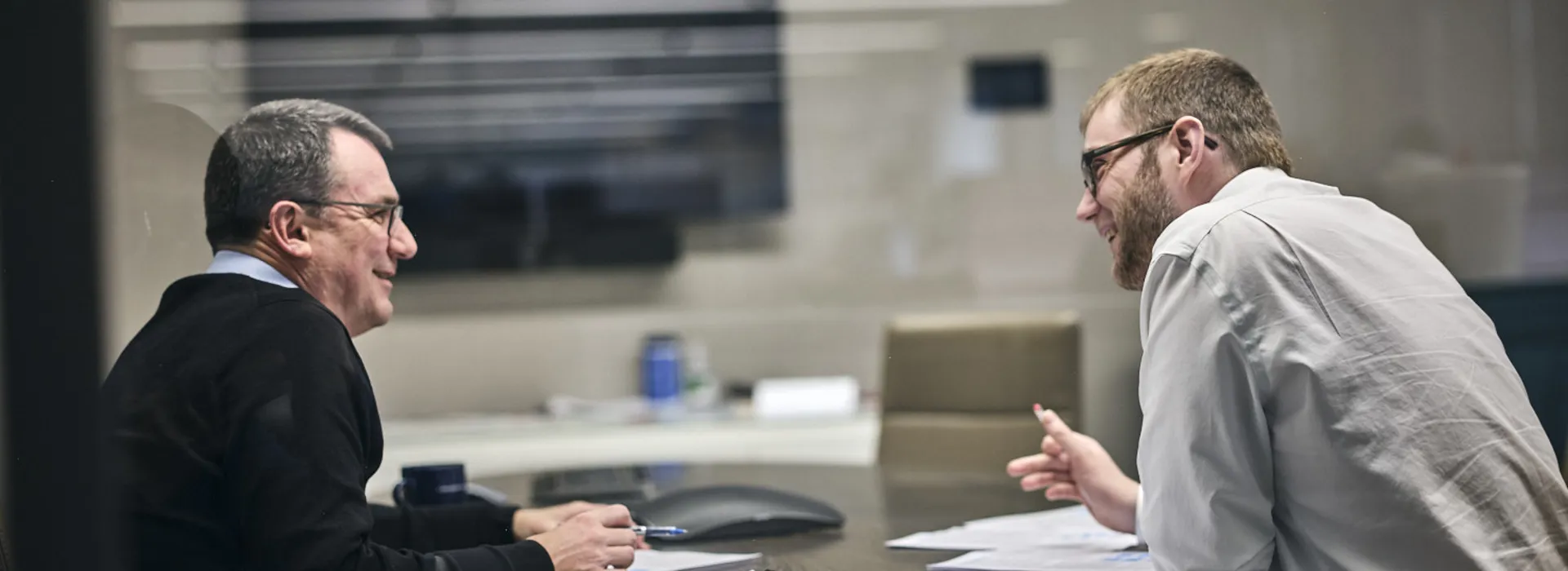two men discussing work in a meeting room