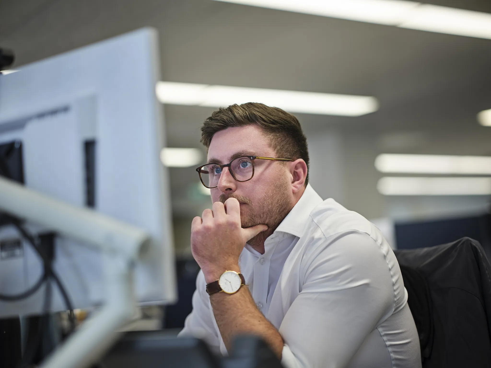 Man looking thoughtfully at a computer screen.