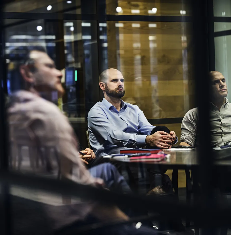 men in meeting, photographed through glass