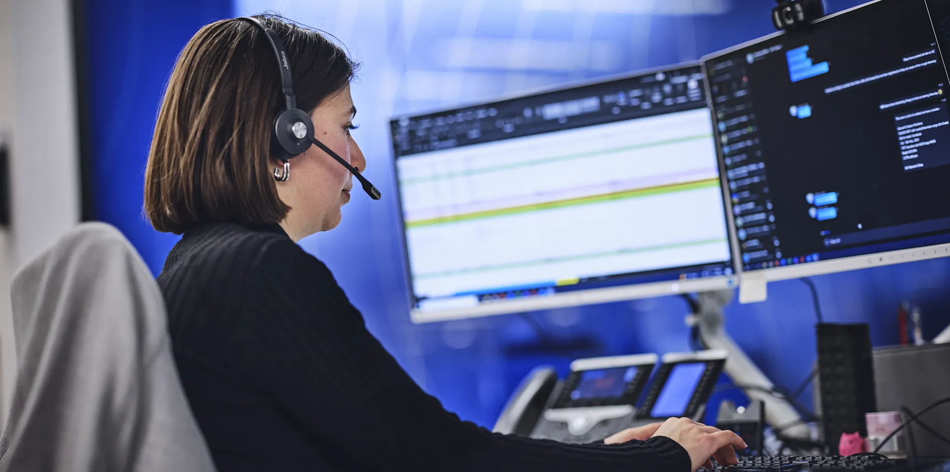 DOEL employee with a headset on at computer