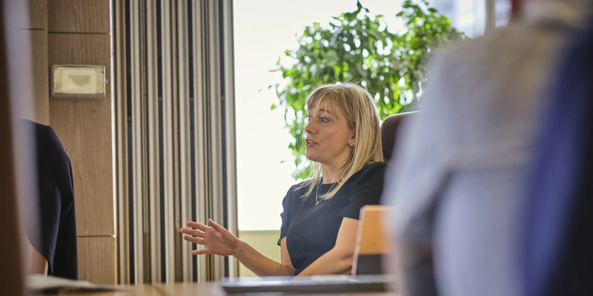 woman sitting talking and gesturing in a meeting