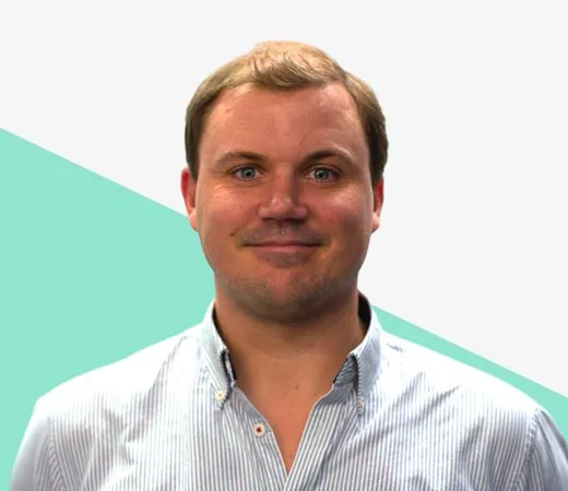 Smiling man in a striped shirt on a light background.
