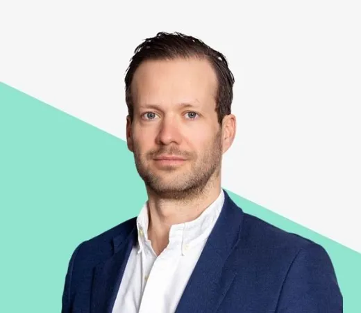 Man in a blazer with a light blue background.