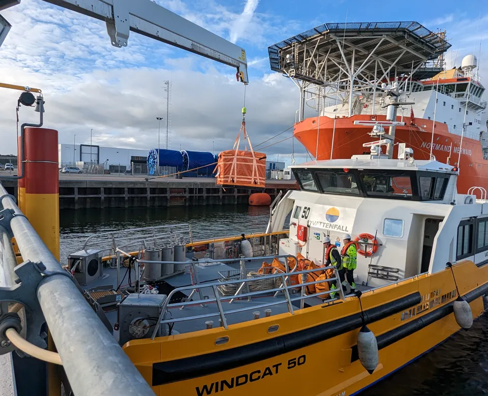 Boat near a large ship in a harbor setting.