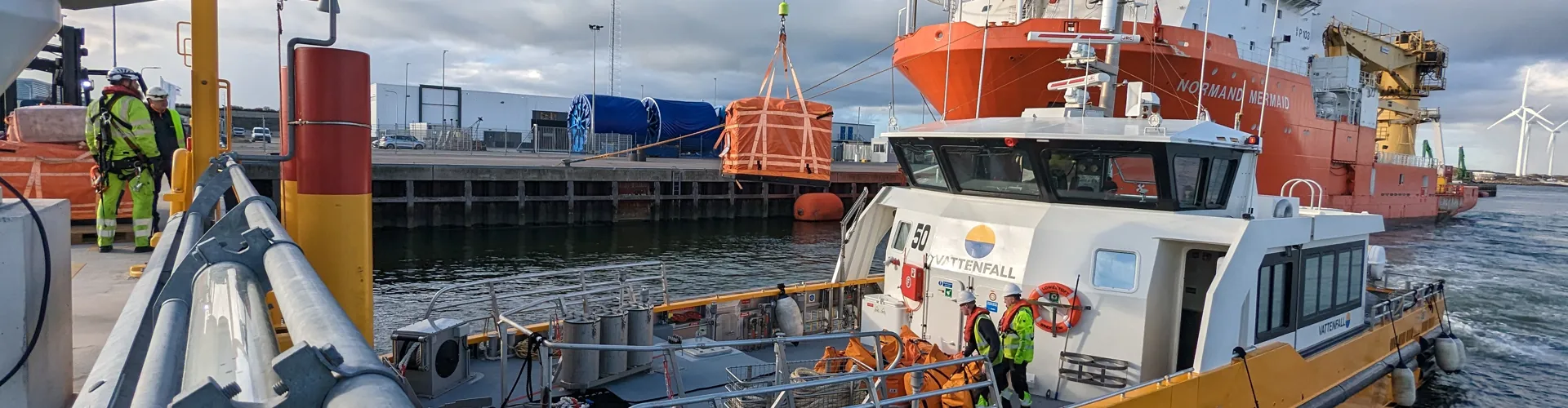 Boat near a large ship in a harbor setting.