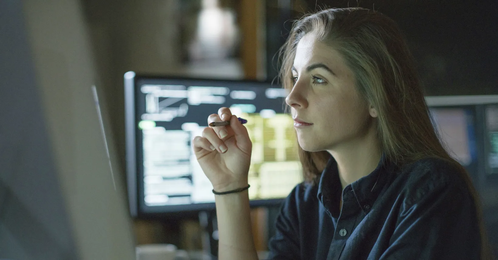 Woman looking at screen with pen