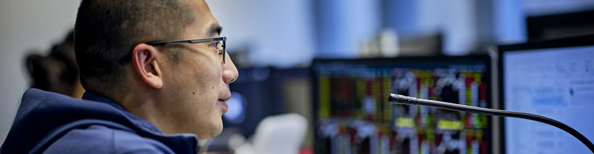 Person using a computer with financial charts displayed.